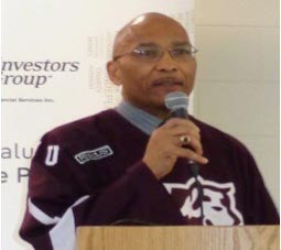 Bob Dawson wearing a Huskies shirt speaking into a microphone.