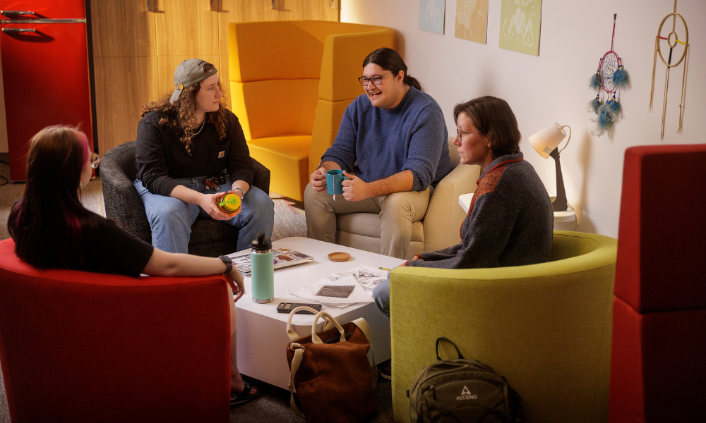 Kylar, the Indigenous student advisor talks with students inside Qomuti